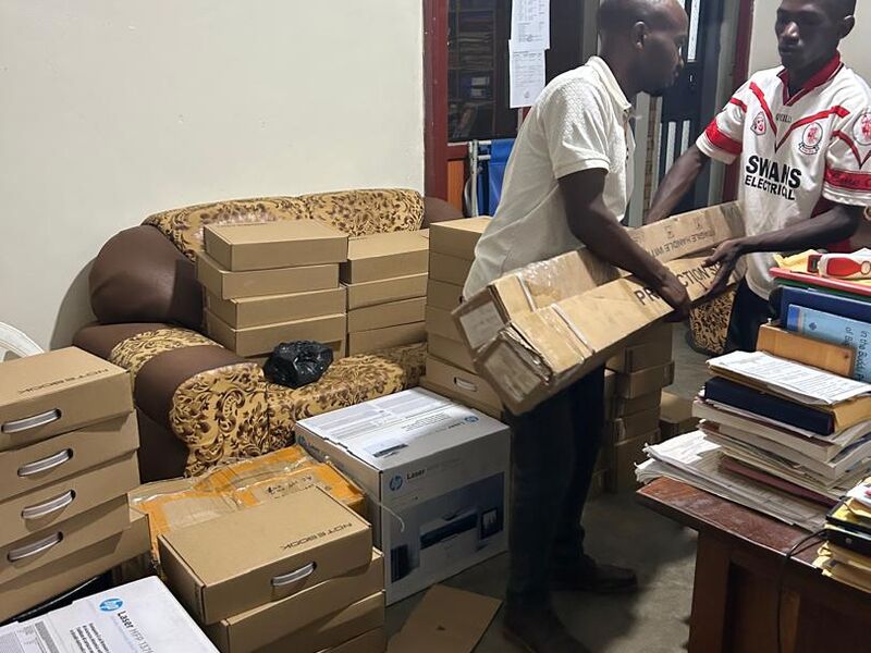 die neuen Computer werden im Büro von John ausgepackt